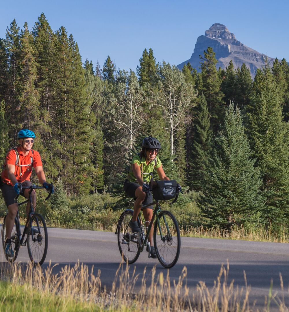 Two people road cycling the Bow Valley Parkway in Banff National Park