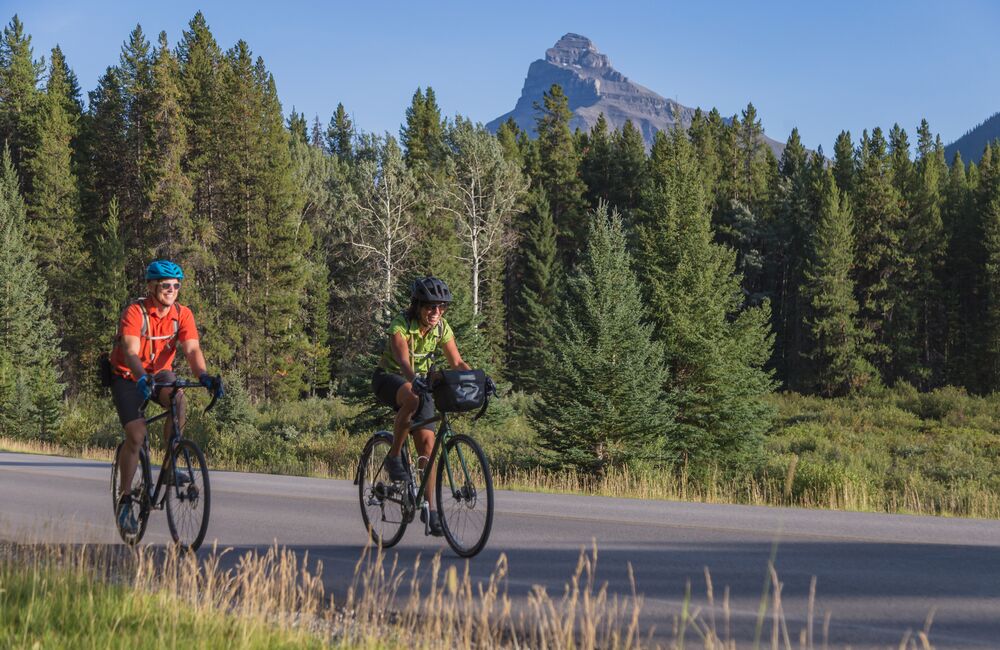 Two people road cycling the Bow Valley Parkway in Banff National Park