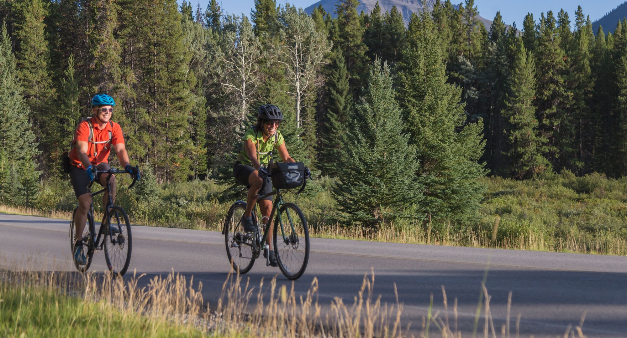 Two people road cycling the Bow Valley Parkway in Banff National Park