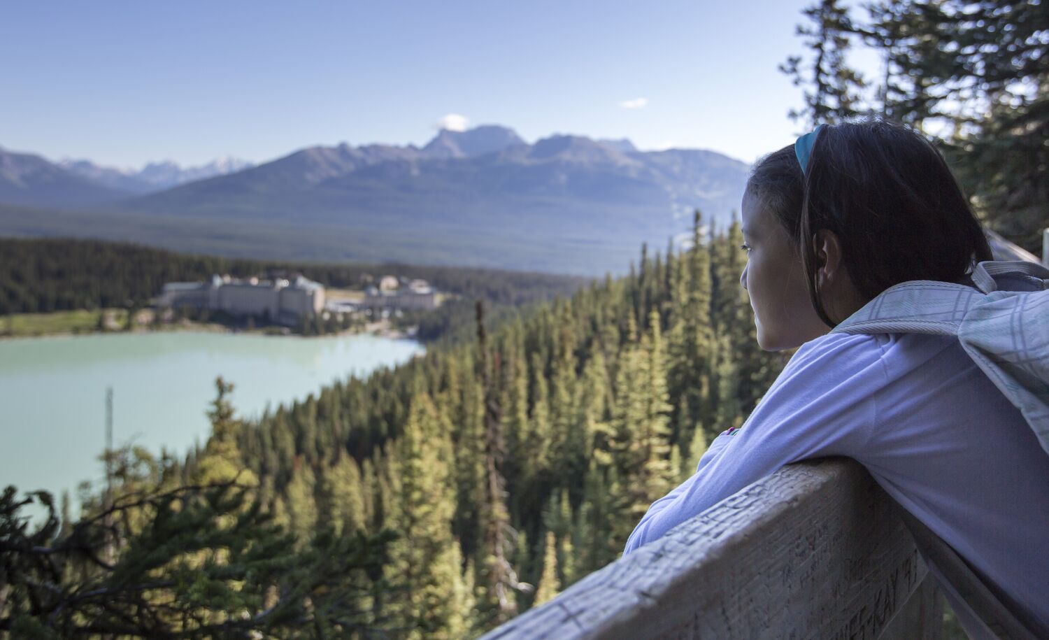A girl hangs off the fence on the Fairview Lookout trail in Lake Louise.