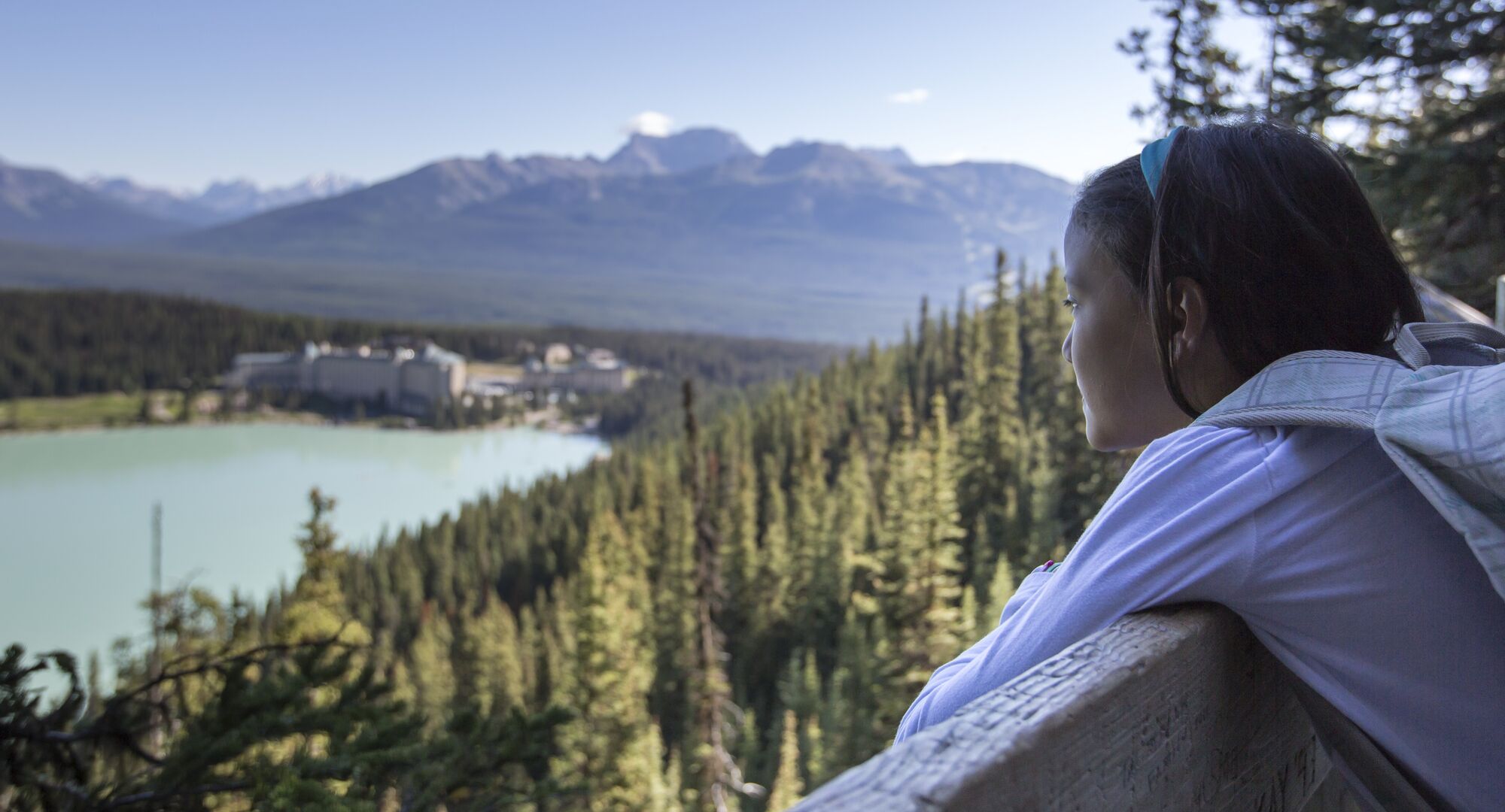 A girl standing at Fairview Lookout looking at the view over Lake Louise in the summer