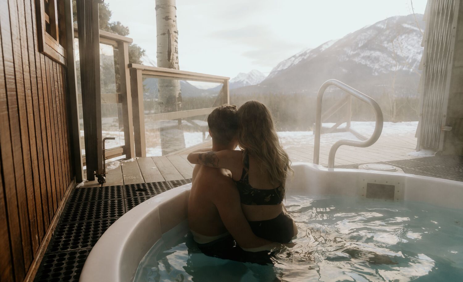 A couple in a hot tub in winter at the Juniper Hotel in Banff.