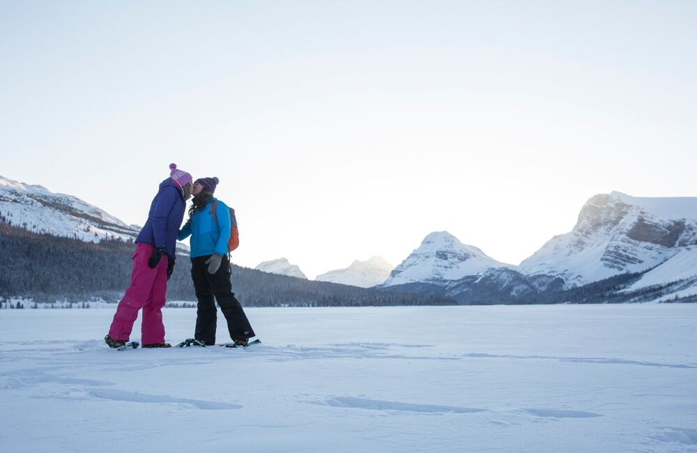 Two snowshoers share a kiss on Bow Lake on the Icefield Parkway in Banff National Park.
