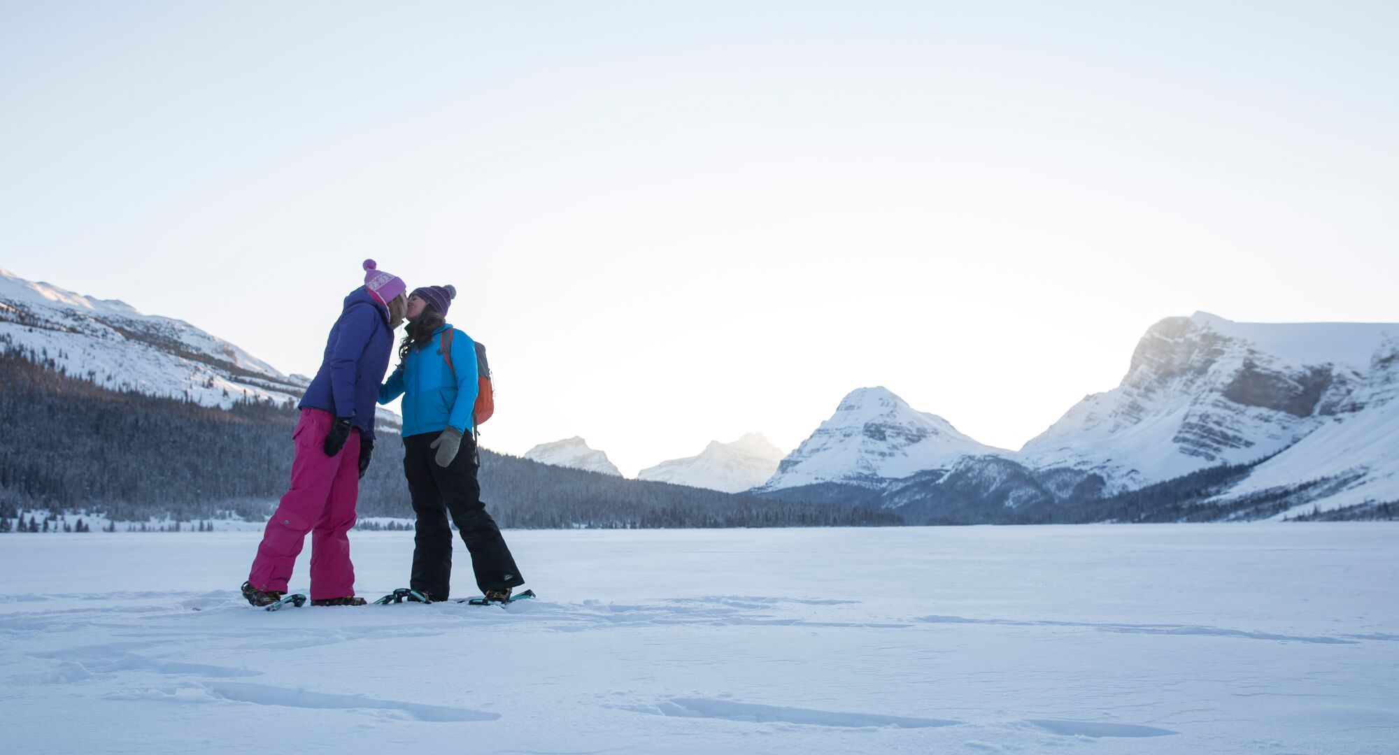 Two snowshoers share a kiss on Bow Lake on the Icefield Parkway in Banff National Park.