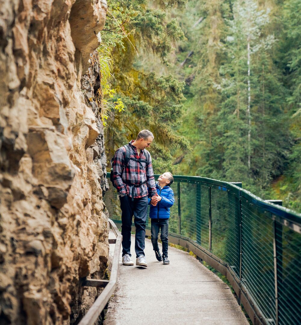 A father and son hiking the Johnston Canyon trail in Banff National Park