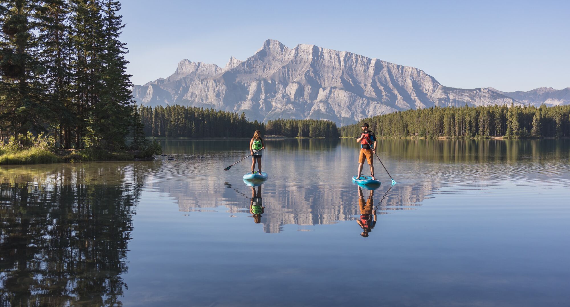 Two paddleboarders on Two Jack Lake in the summer