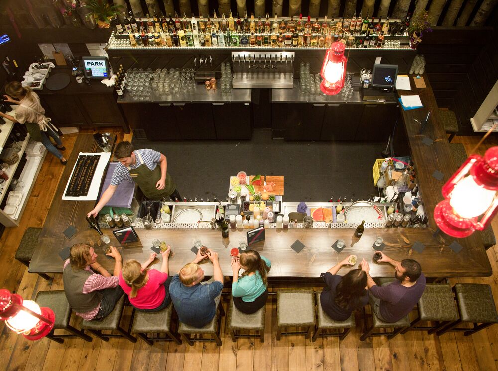 People seen from above sitting at the bar at PARK Distillery in Banff National Park.