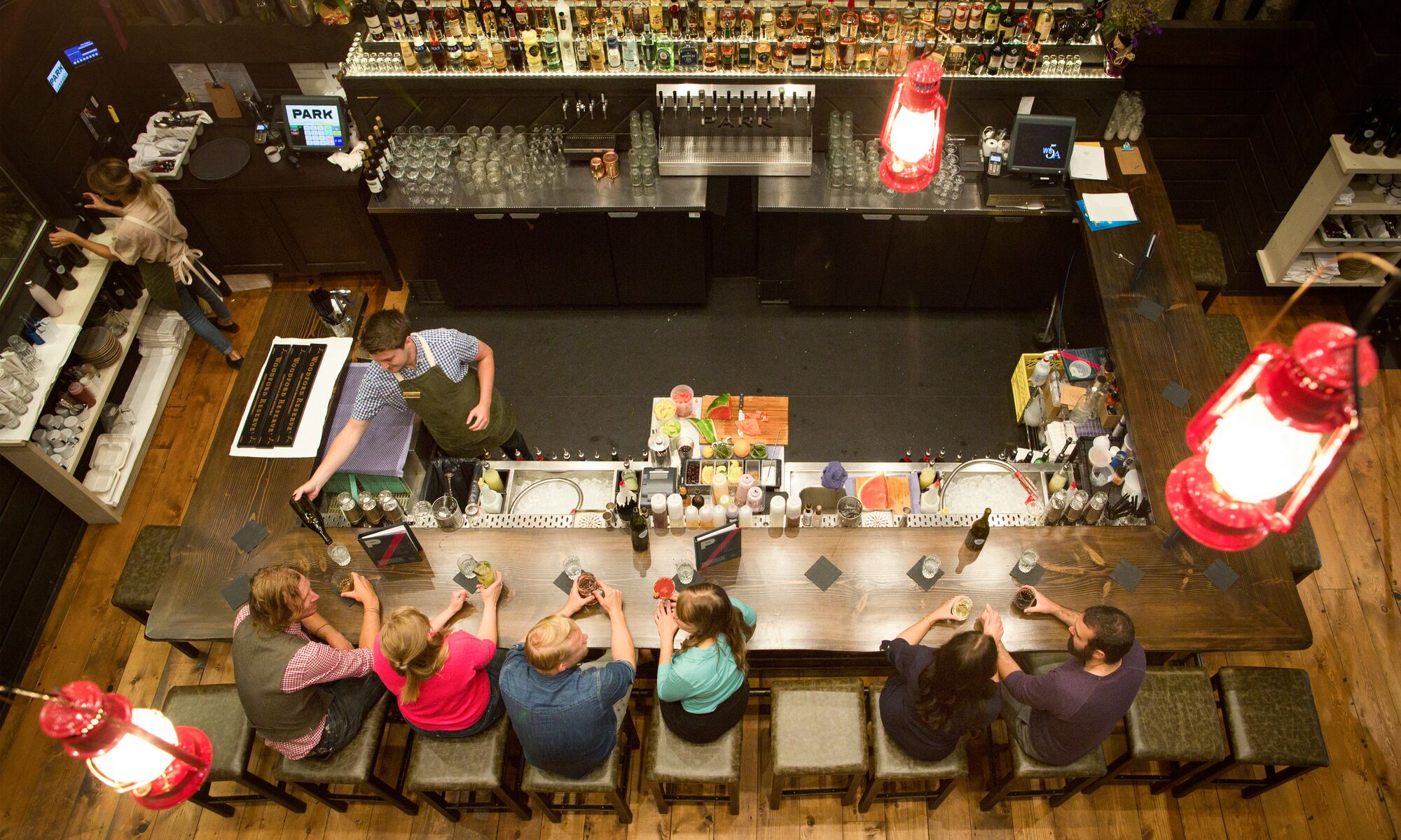 People seen from above sitting at the bar at PARK Distillery in Banff National Park.