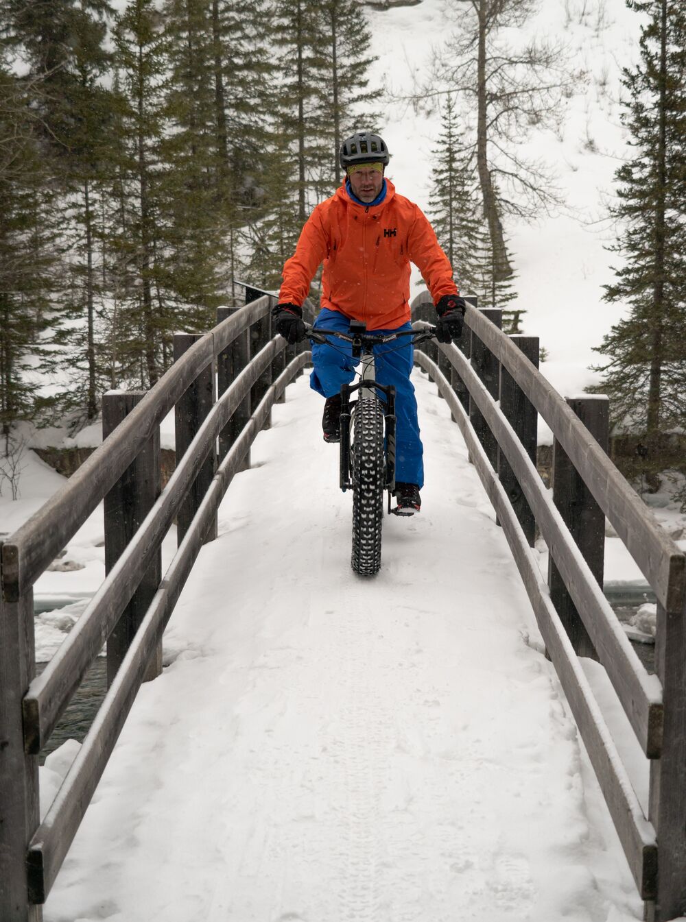 バンフ国立公園の橋を自転車で渡る人。