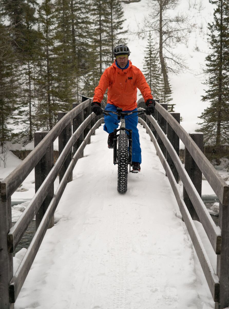 A person fat bikes over a bridge in Banff National Park.