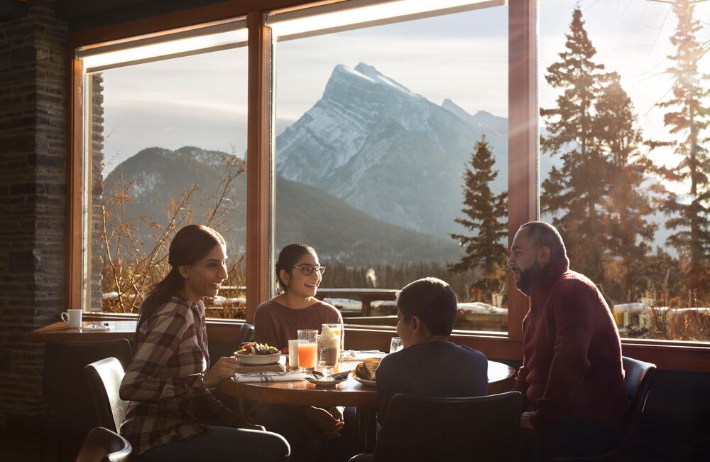 A family sits at the window in the Juniper Bistro overlooking Banff