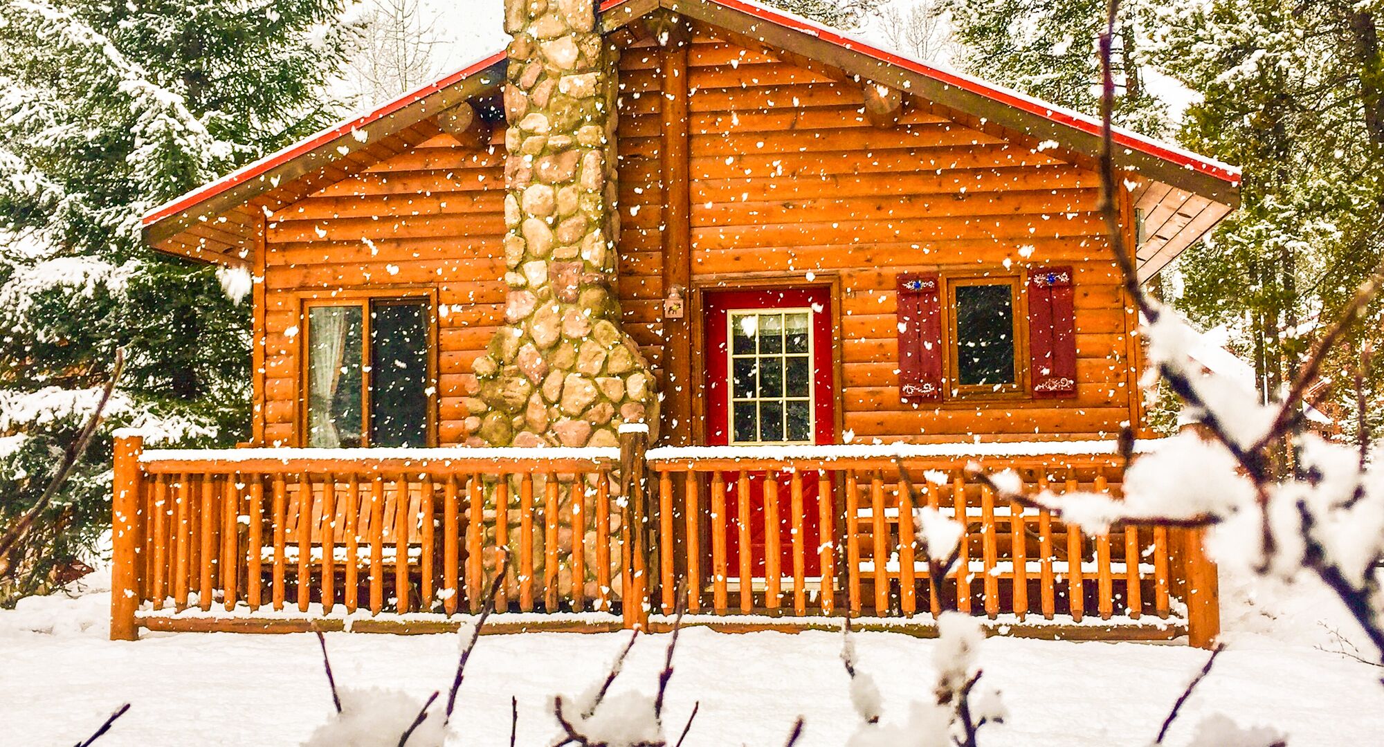 A cozy cabin in the woods in Banff National Park in the winter with snow falling.
