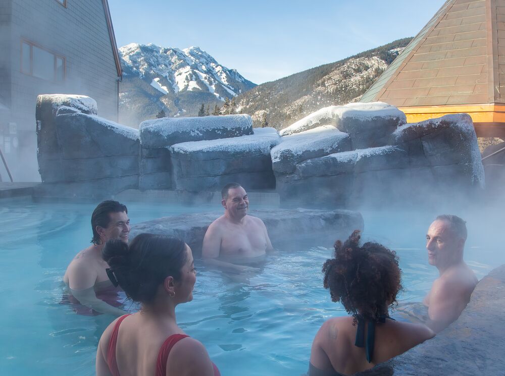 People enjoying the hot tub at Hotel Canoe & Suites in Banff in the winter.
