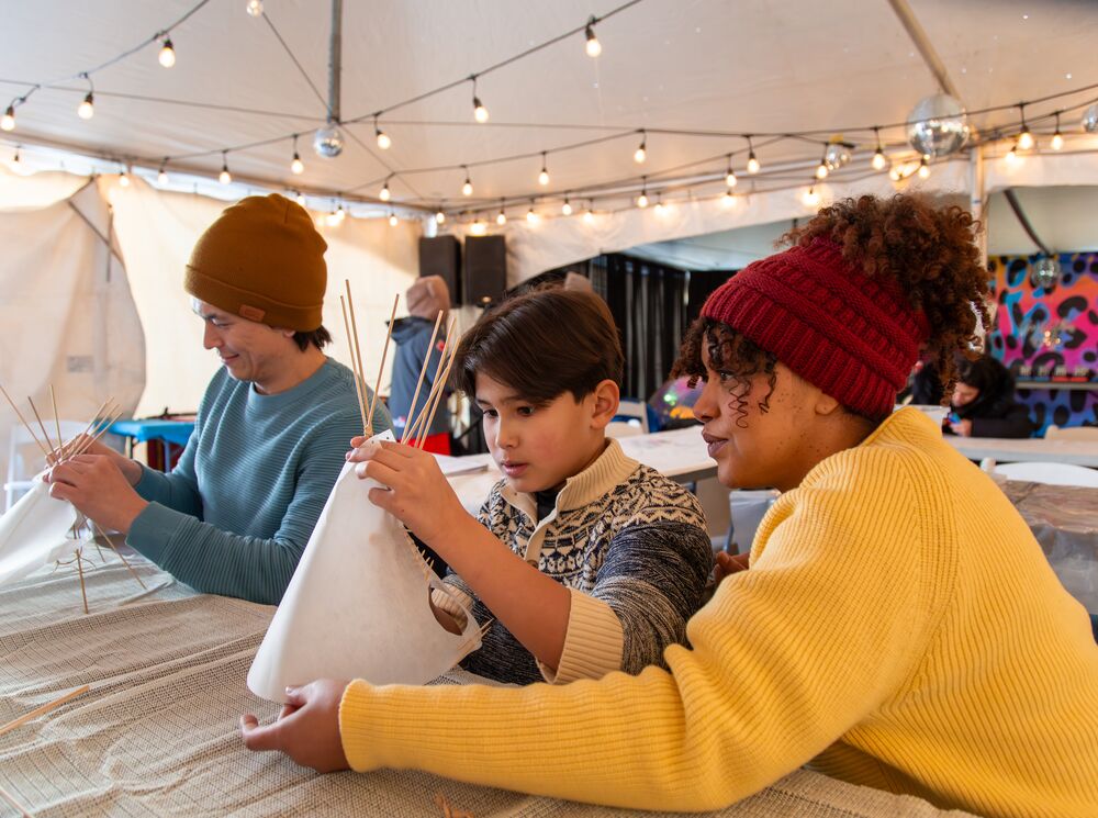 A family builds a mini teepee at Weekend of Wonder at Snow Days in Banff.