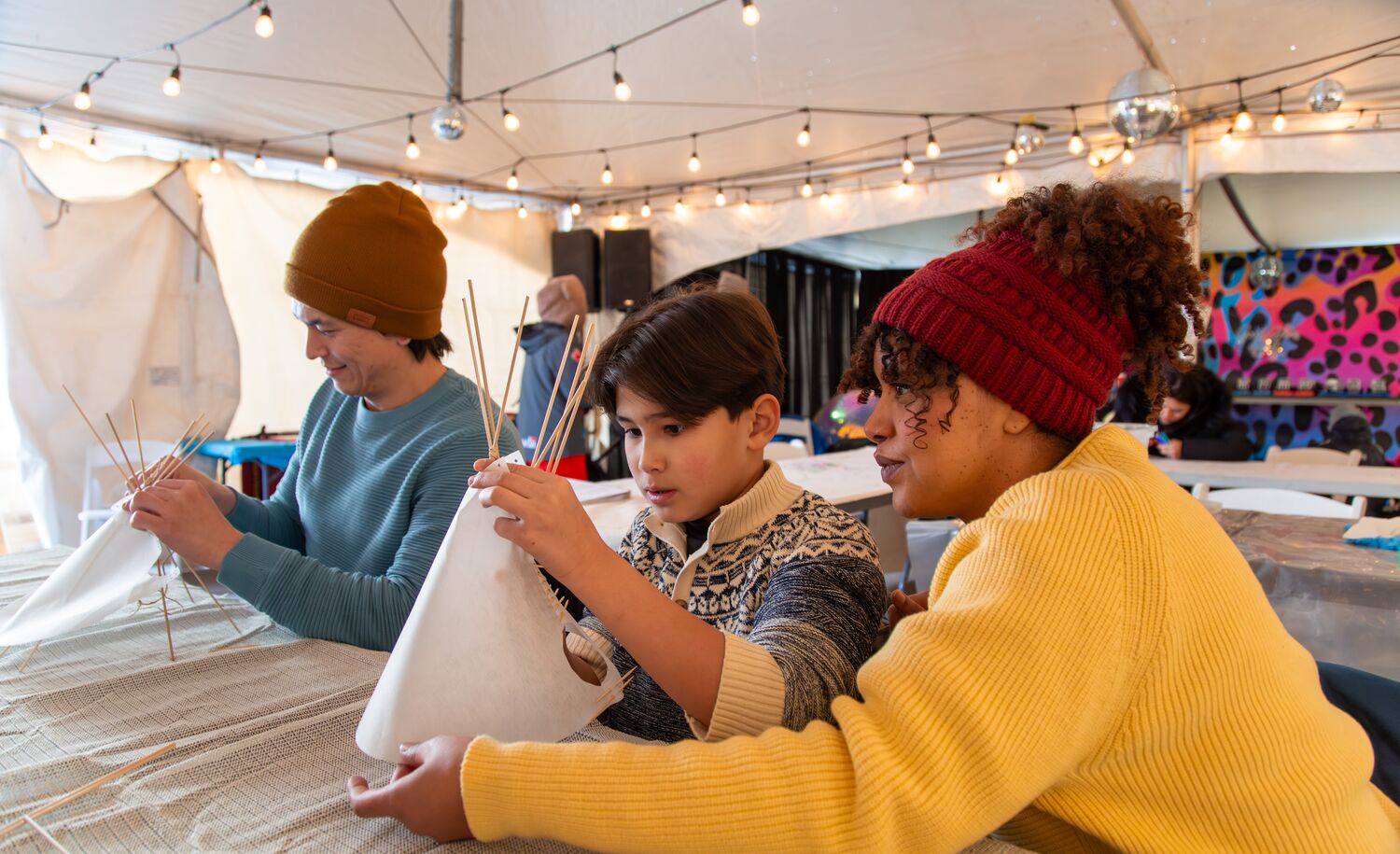 A family builds a mini teepee at Weekend of Wonder at Snow Days in Banff.
