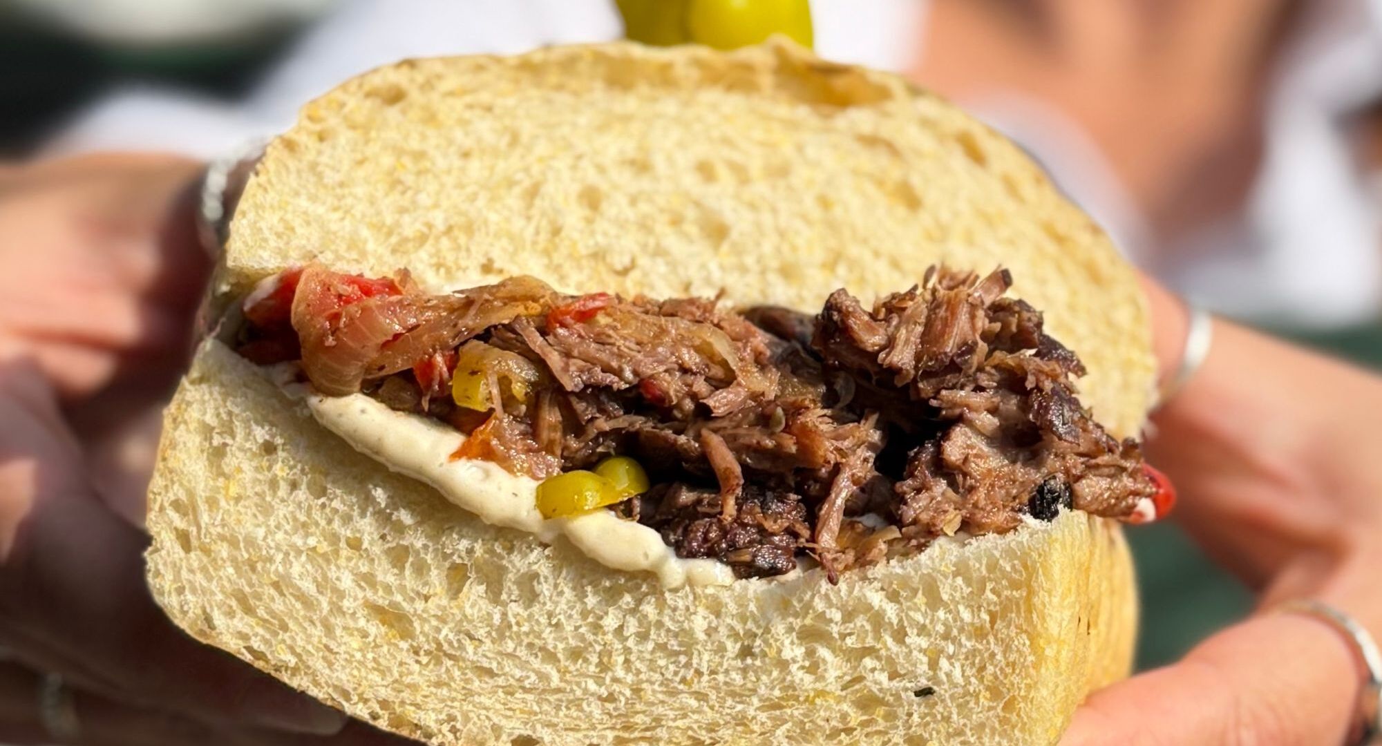 Italian Beef Sandwich - Braised beef short rib, pepperoncini, marinated peppers, caramelized onion, horseradish & bone marrow aioli on focaccia