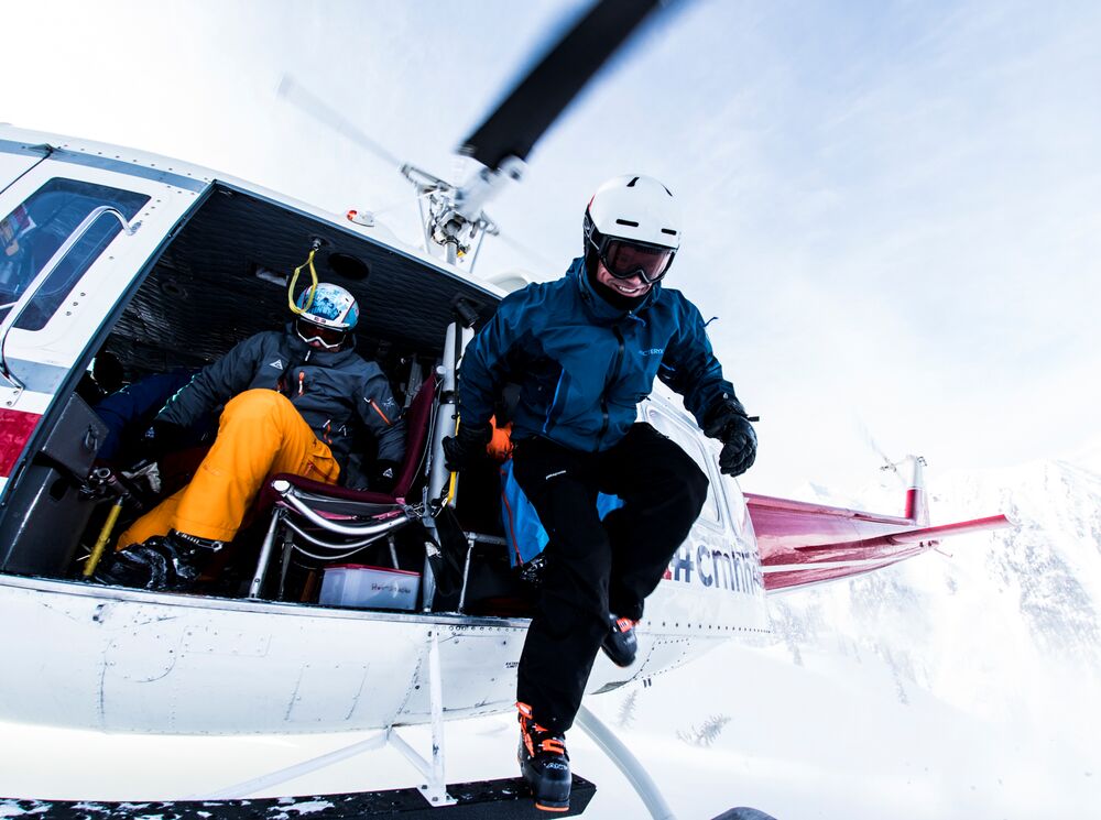 Skiers jump out of a helicopter during a heli-skiing trip with CMH.