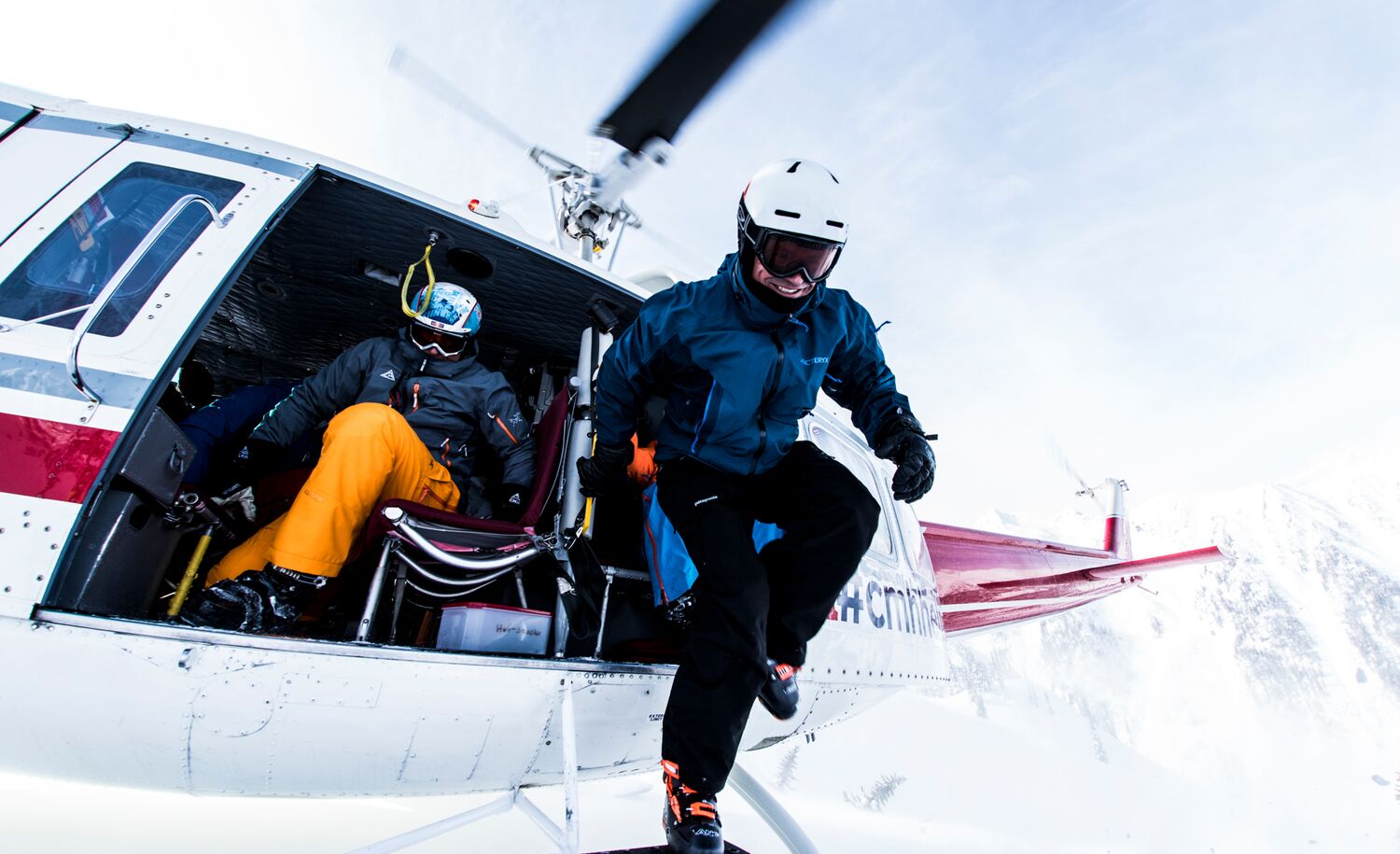 Skiers jump out of a helicopter during a heli-skiing trip with CMH.