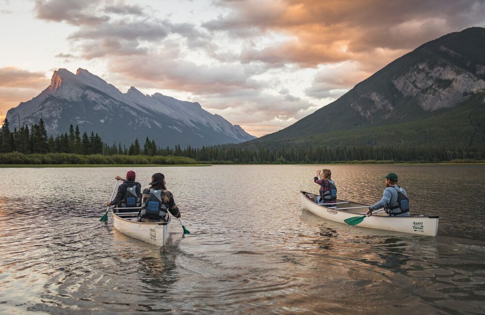 Two canoes on Vermilion Lakes at sunrise in Banff National Park.