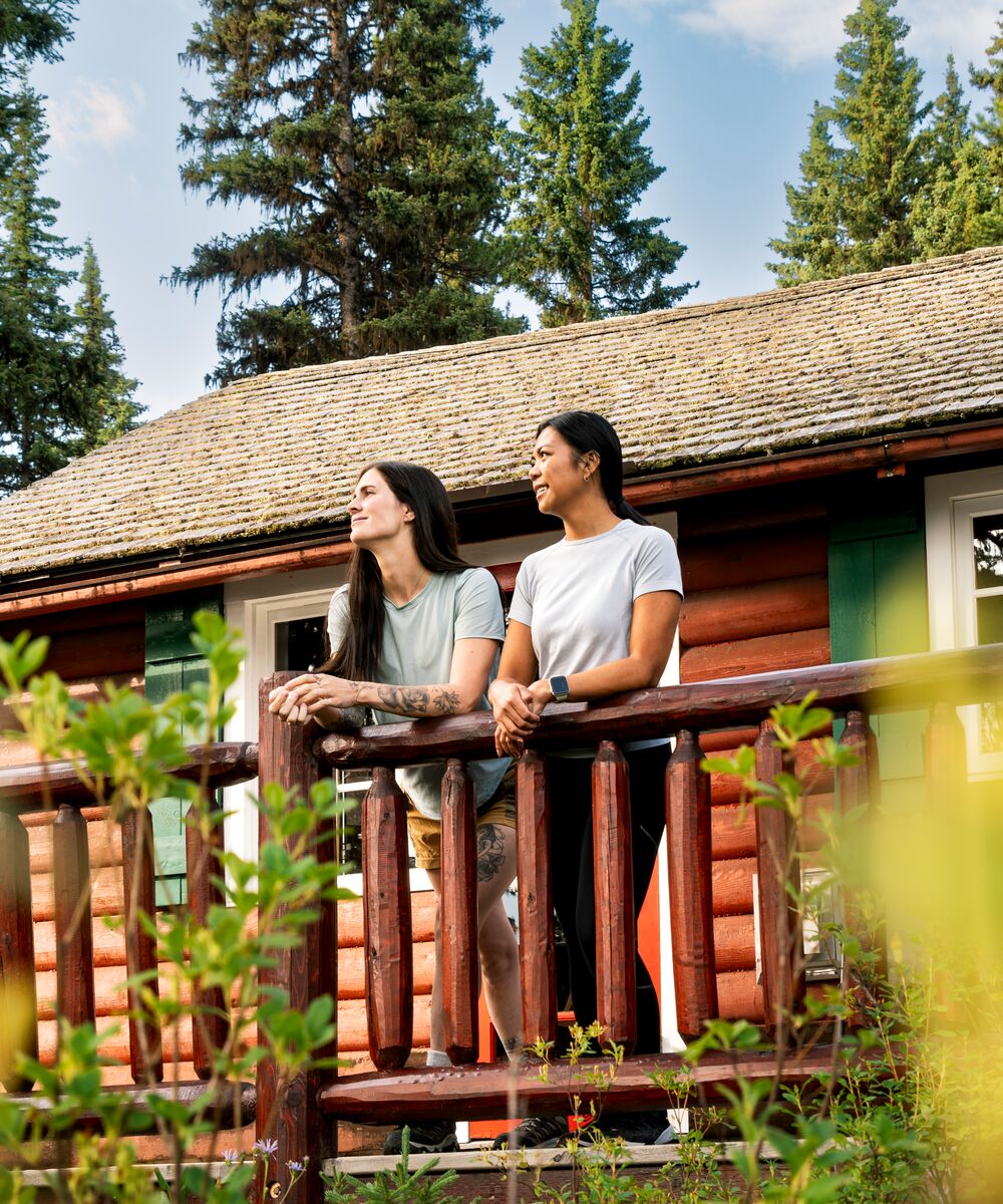 Two people looking out from the balcony of a cabin in Banff National Park