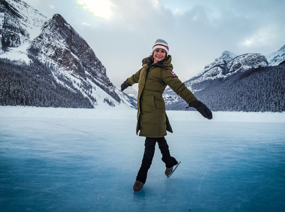 A woman skates on a frozen Lake Louise in Banff National Park in the winter.