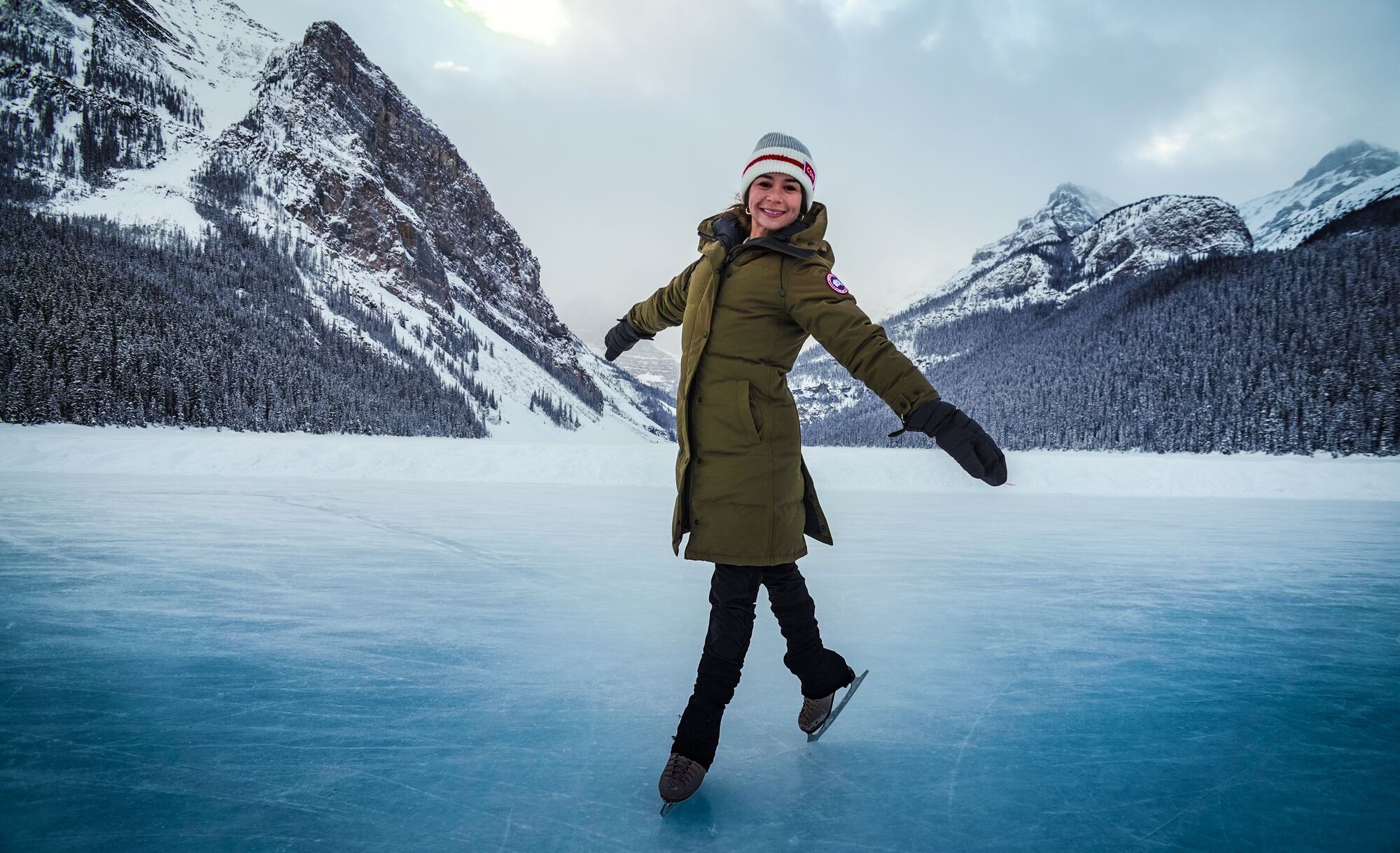 A woman skates on a frozen Lake Louise in Banff National Park in the winter.