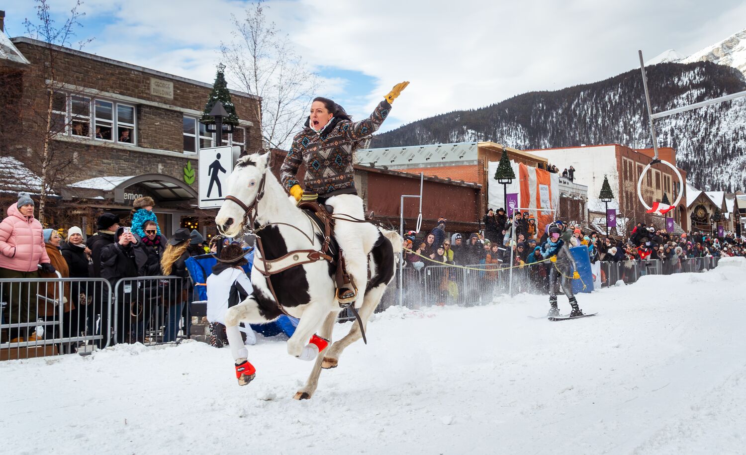 A horse and rider pull a skier down Banff Avenue during Skijoring in Banff.