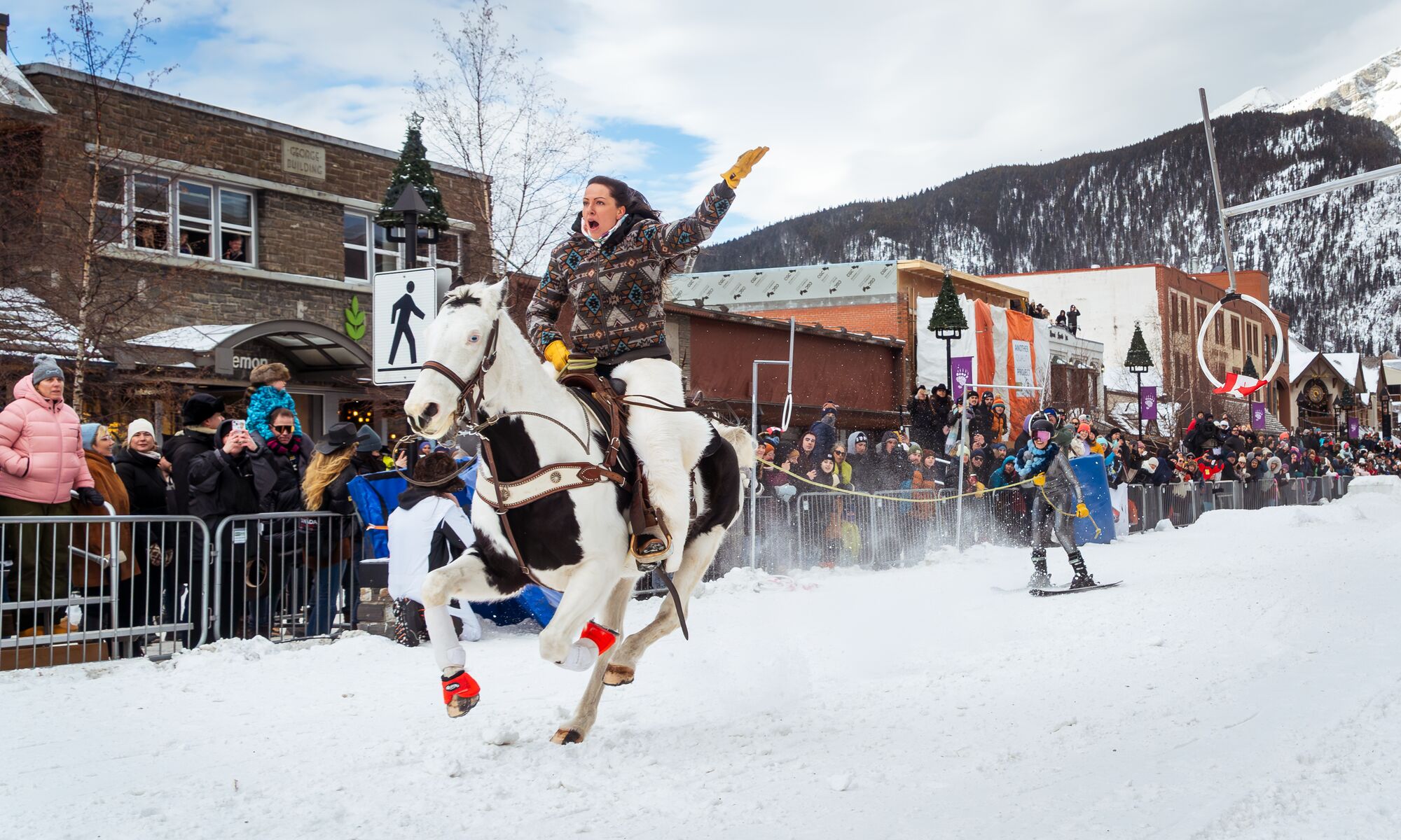 A horse and rider pull a skier down Banff Avenue during Skijoring in Banff.