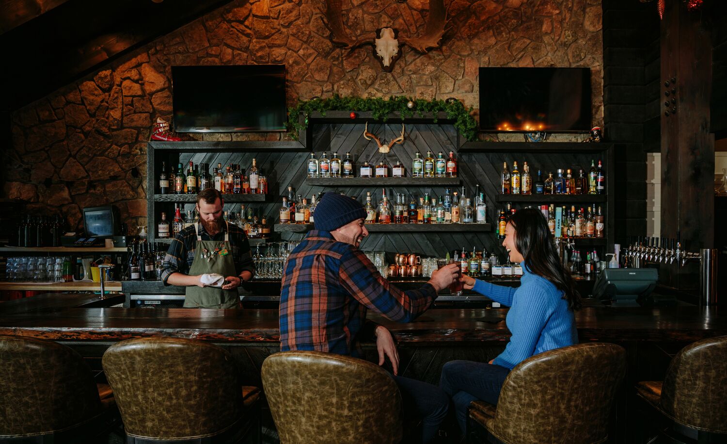 Two people sit at the bar at Park Distillery in Banff National Park.