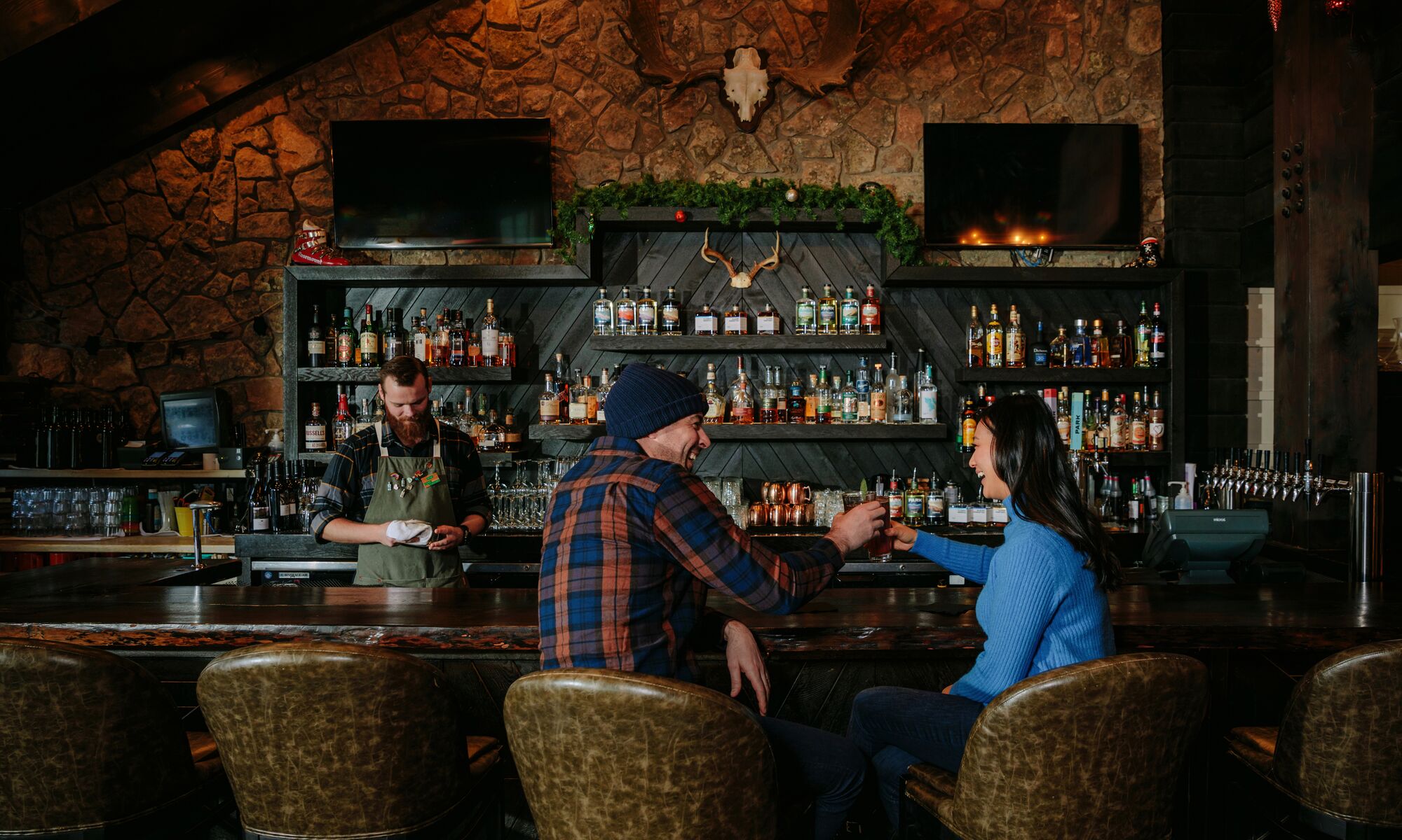 Two people sit at the bar at Park Distillery in Banff National Park.