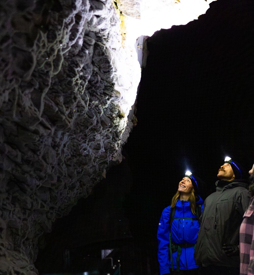 Three people with headlamps on, on a guided night hike through Johnston Cayon in the winter.