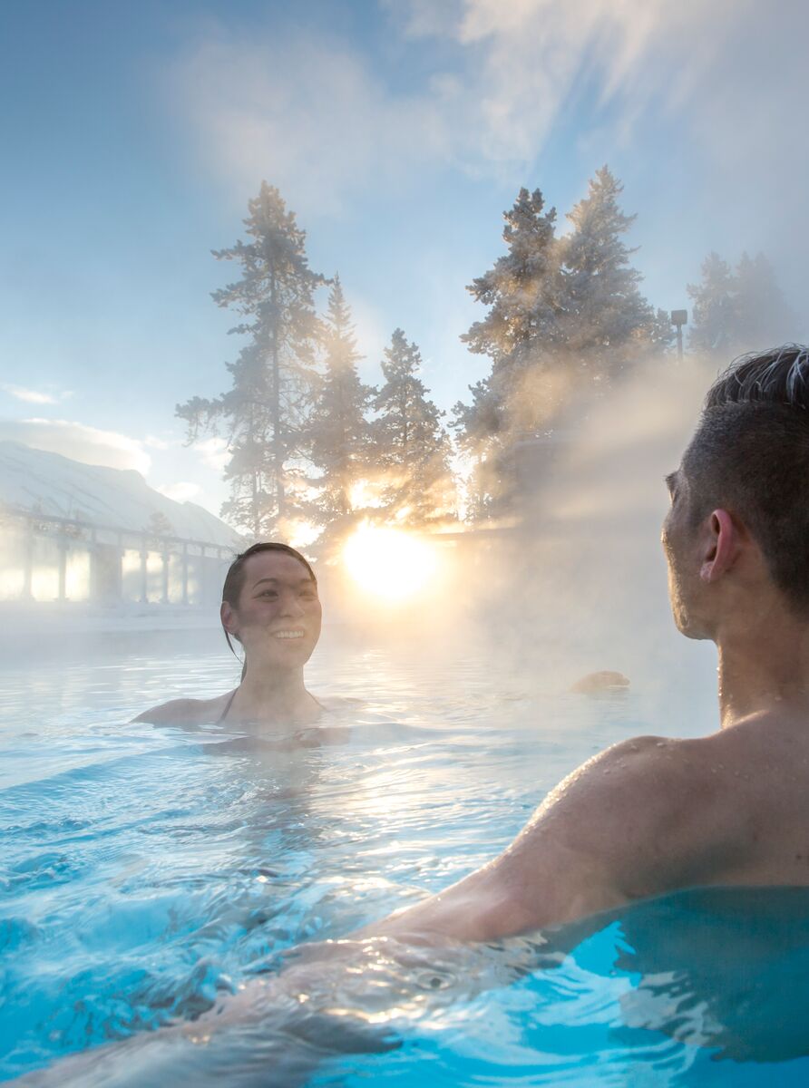Two people float in the waters of the Banff Upper Hot Springs in Banff, Canada.