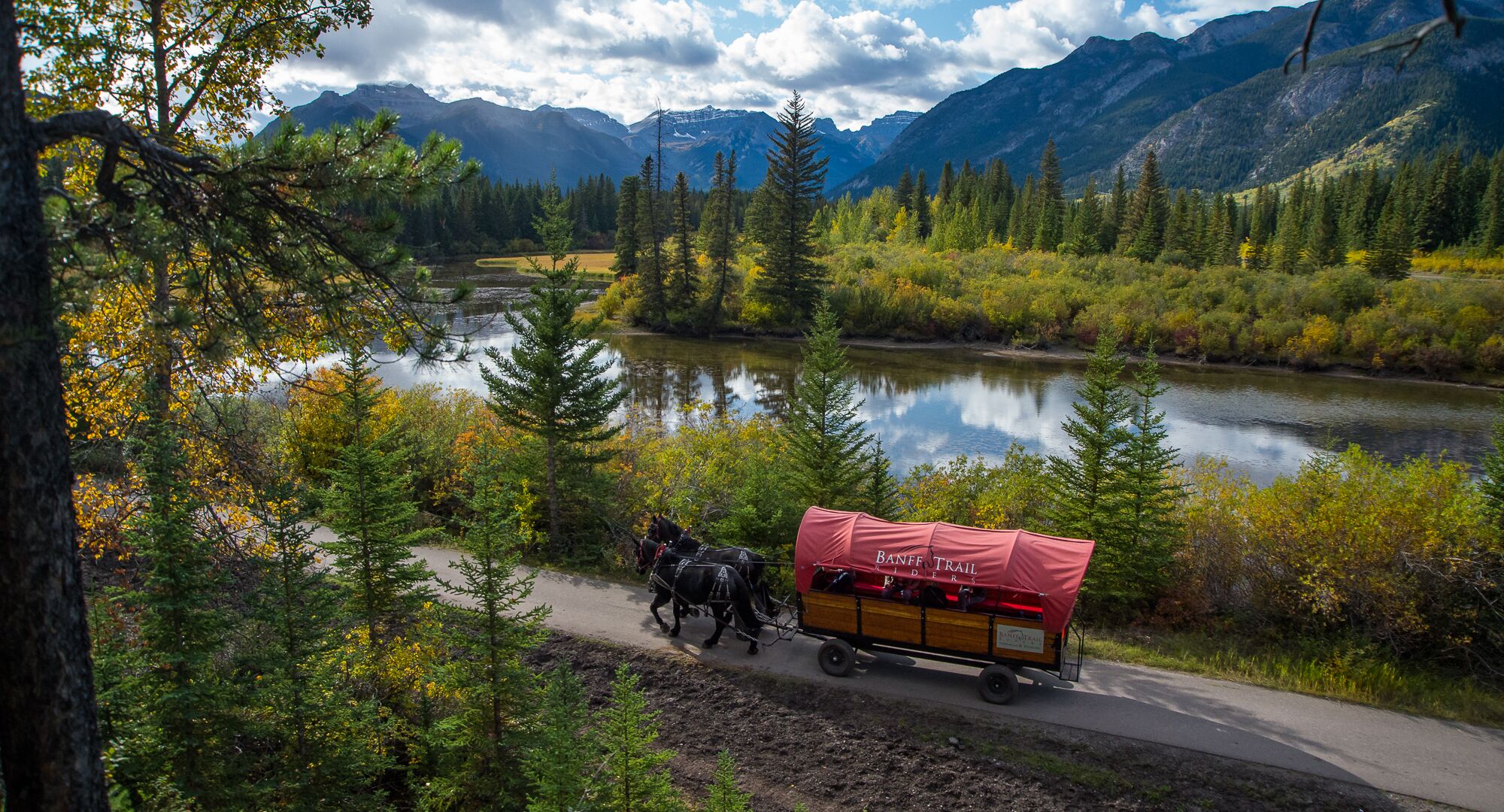 A horse drawn wagon following a trail along the river
