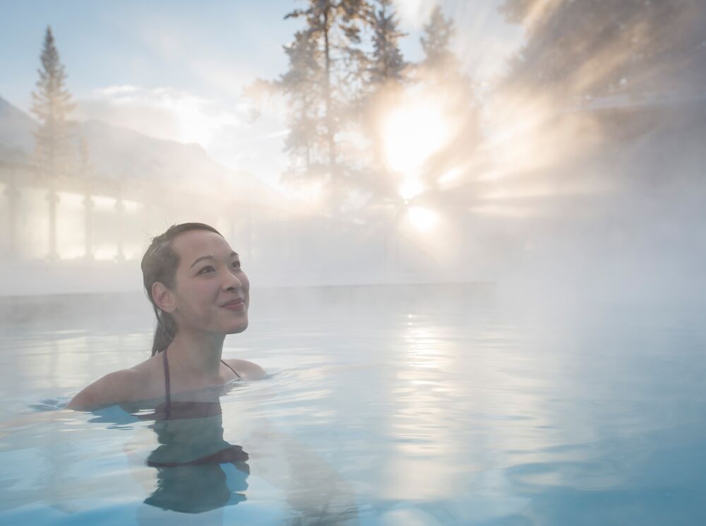 A woman swims in the Banff Upper Hot Springs in the winter.