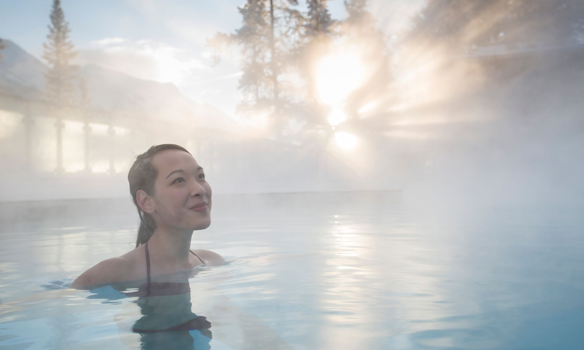 A woman swims in the Banff Upper Hot Springs in the winter.