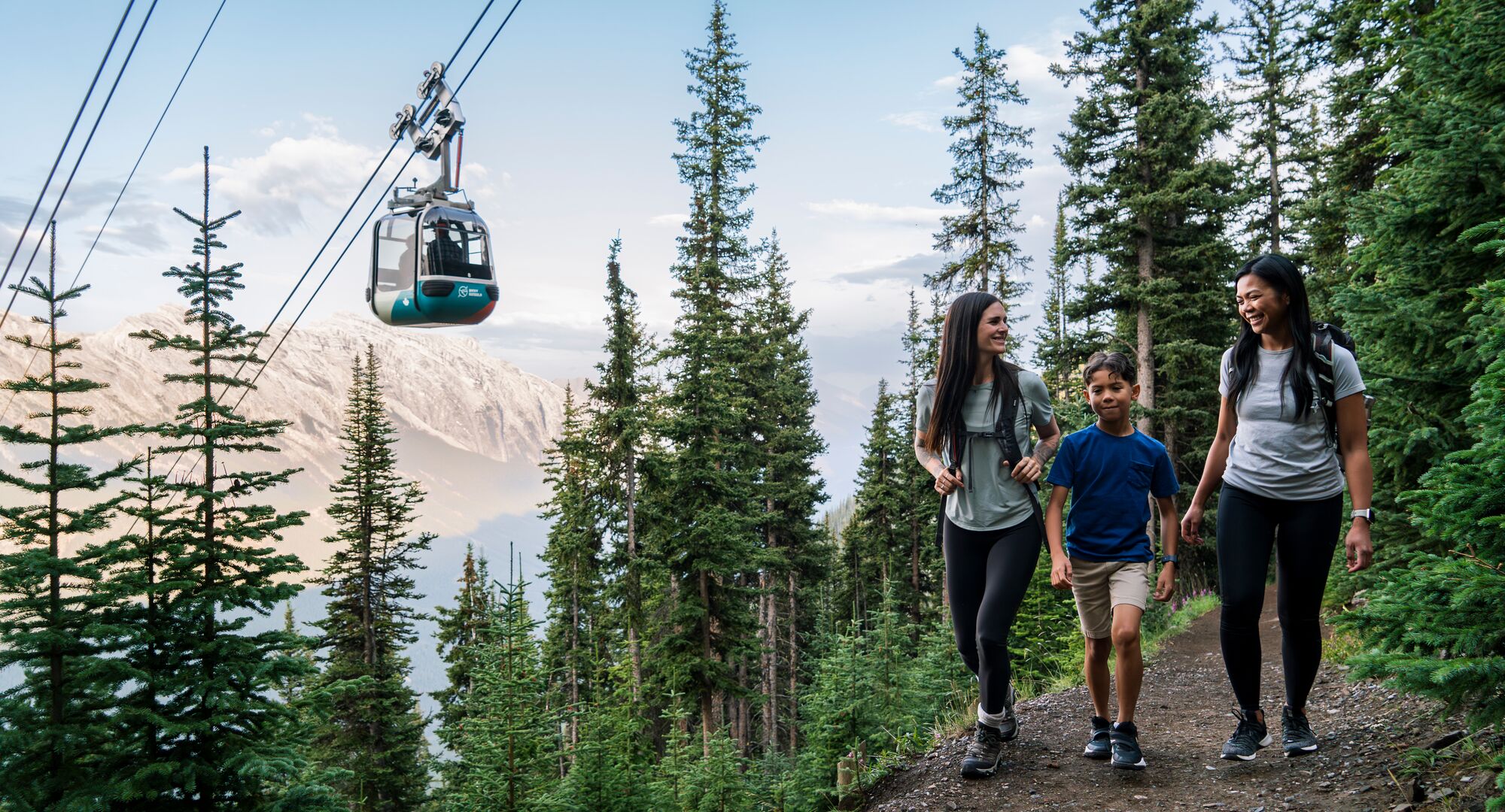 A group of people hiking the Sulphur Mountain trail under the Banff Gondola.