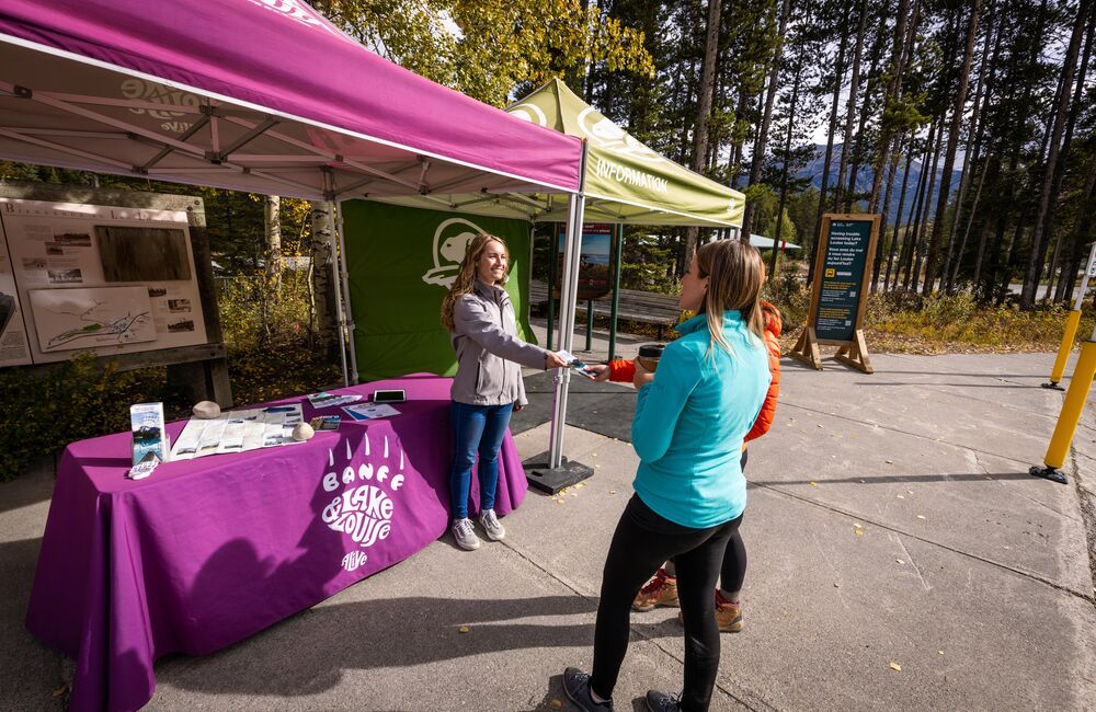 A visitor services team member with Banff Lake Louise Tourism greets guests at the Lake Louise Visitor Centre