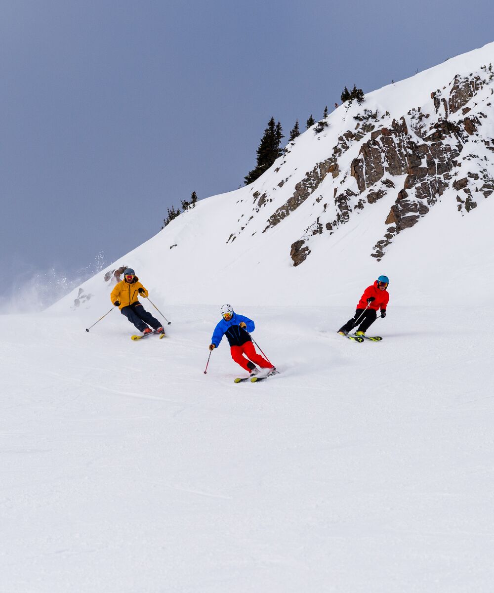 A group of friends skiing a run at the Lake Louise Ski Resort in Banff National Park