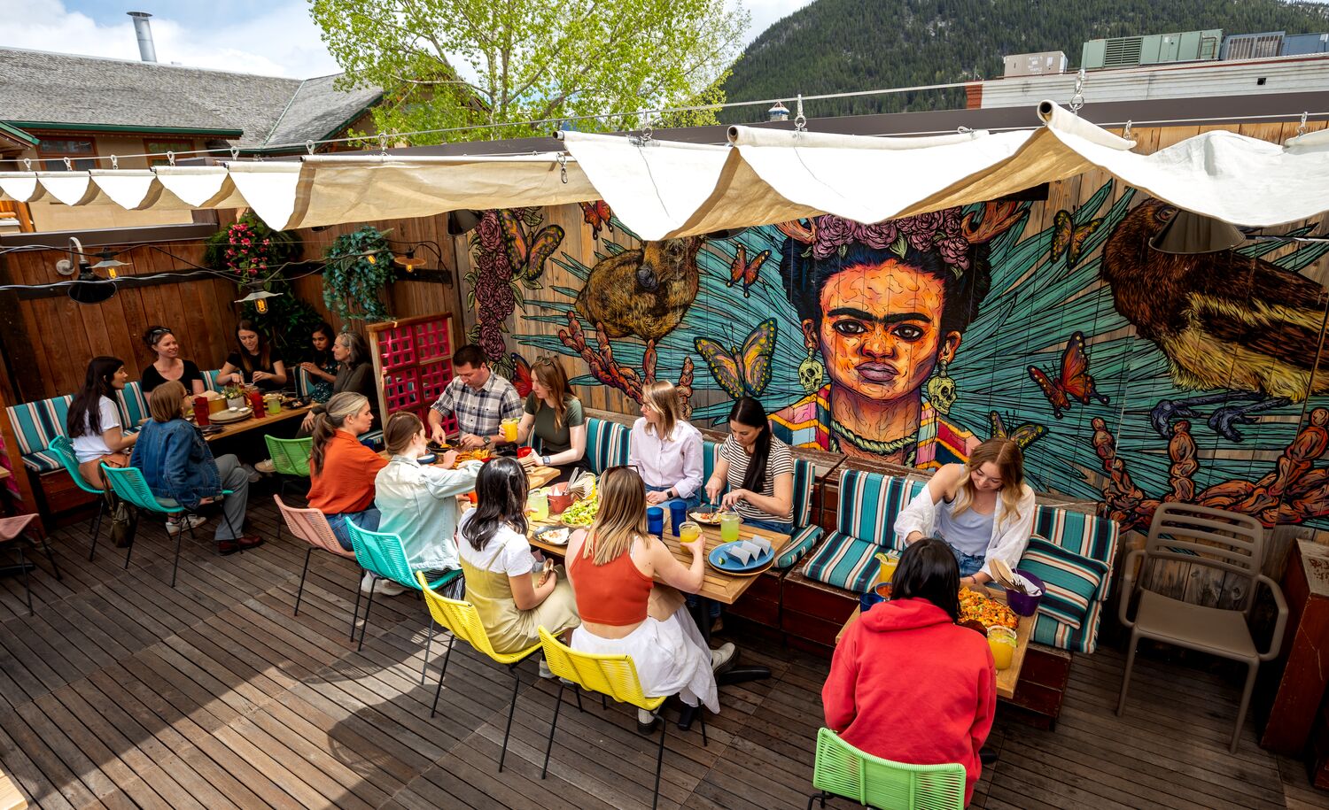 People sit in the sunshine on El Patio, a rooftop terrace bar, in Banff.
