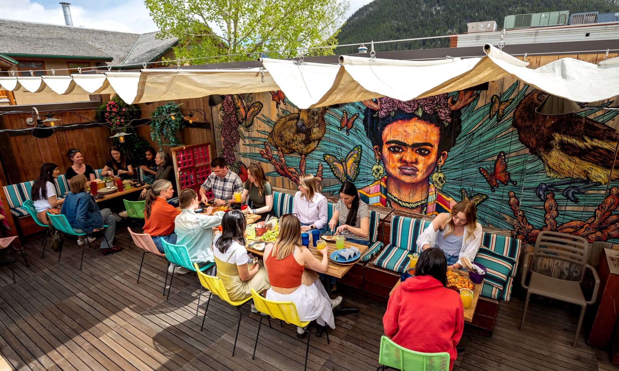 People sit in the sunshine on El Patio, a rooftop terrace bar, in Banff.