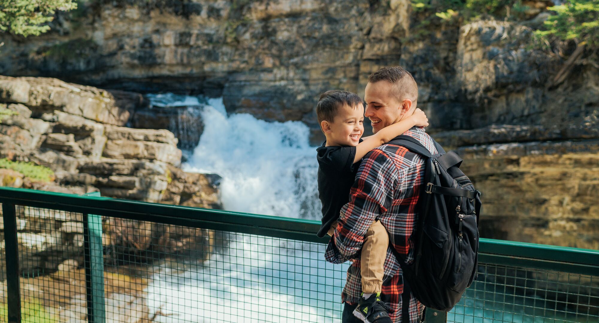 A father and son taking in the views of the falls on the Johnston Canyon trail