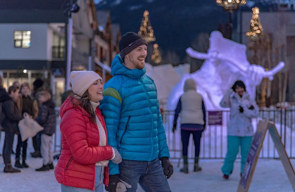 A couple exploring Bear Street in the evening during SnowDays