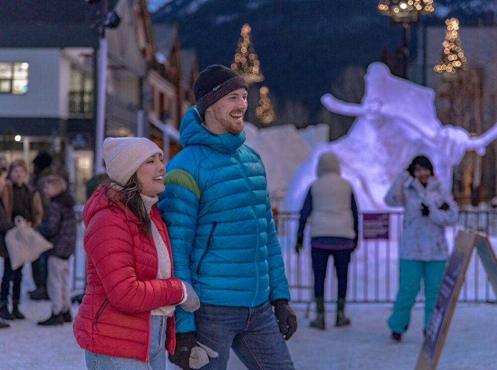 A couple exploring Bear Street in the evening during SnowDays