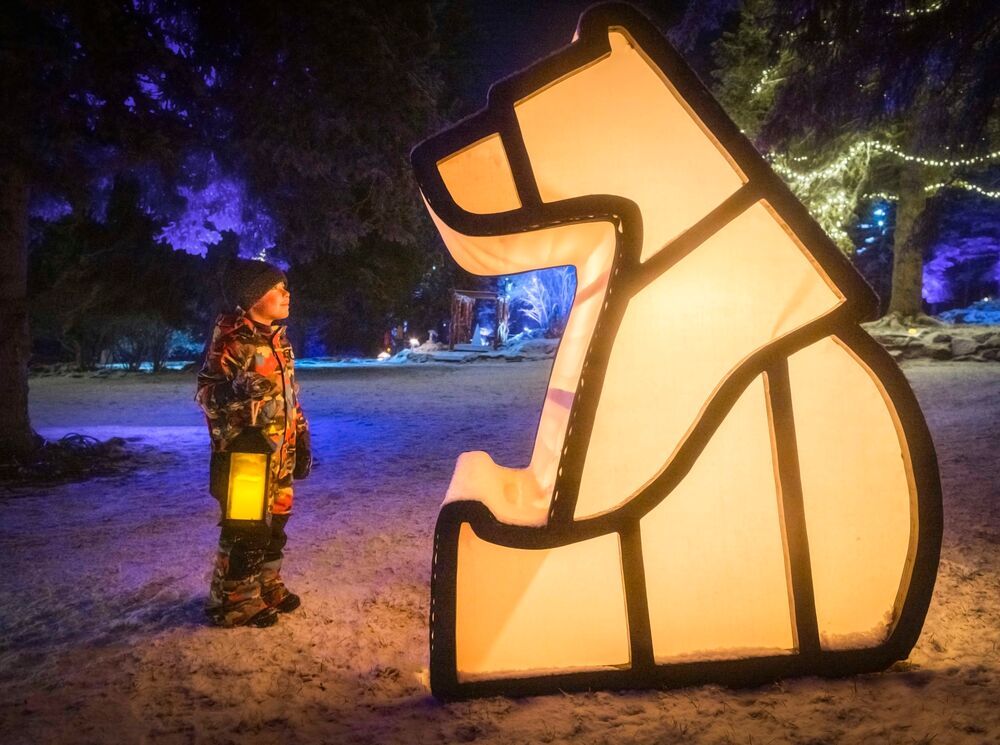 A family on a lantern walk in search of Christmas spirit in Banff National Park.