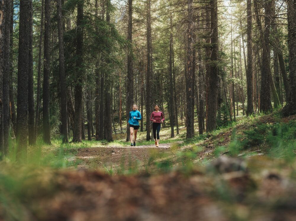 Two people running Boom Lake trail in Banff National Park