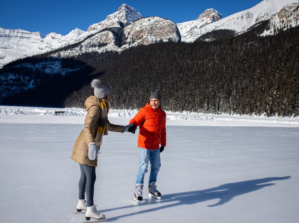 A couple skating on Lake Louise in the winter in Banff National Park