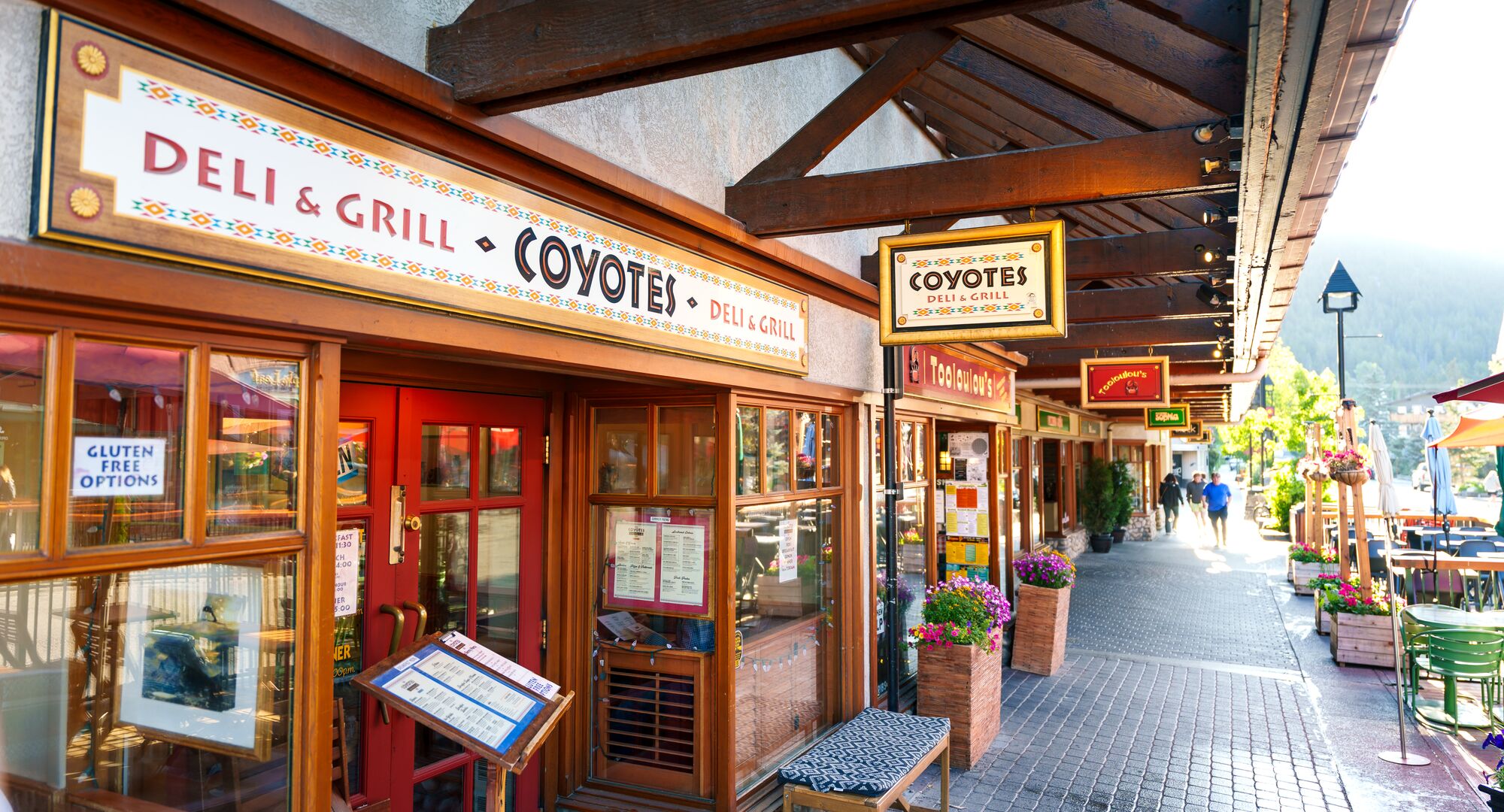 An outside street view of Coyotes Southwestern Grill and other restaurants on Caribou Street in Banff