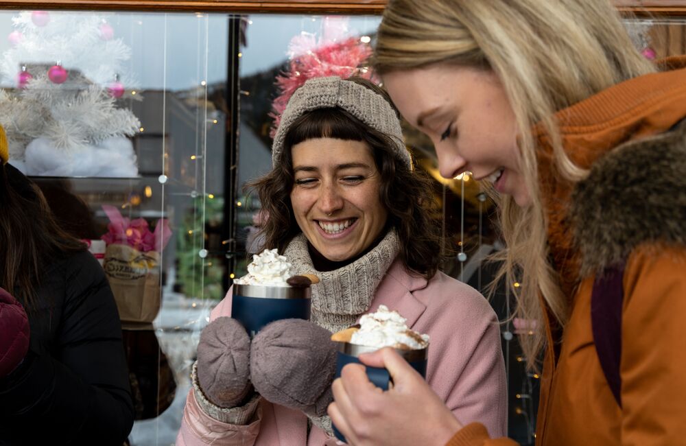 Two people enjoying hot chocolates for the hot chocolate trail in Banff