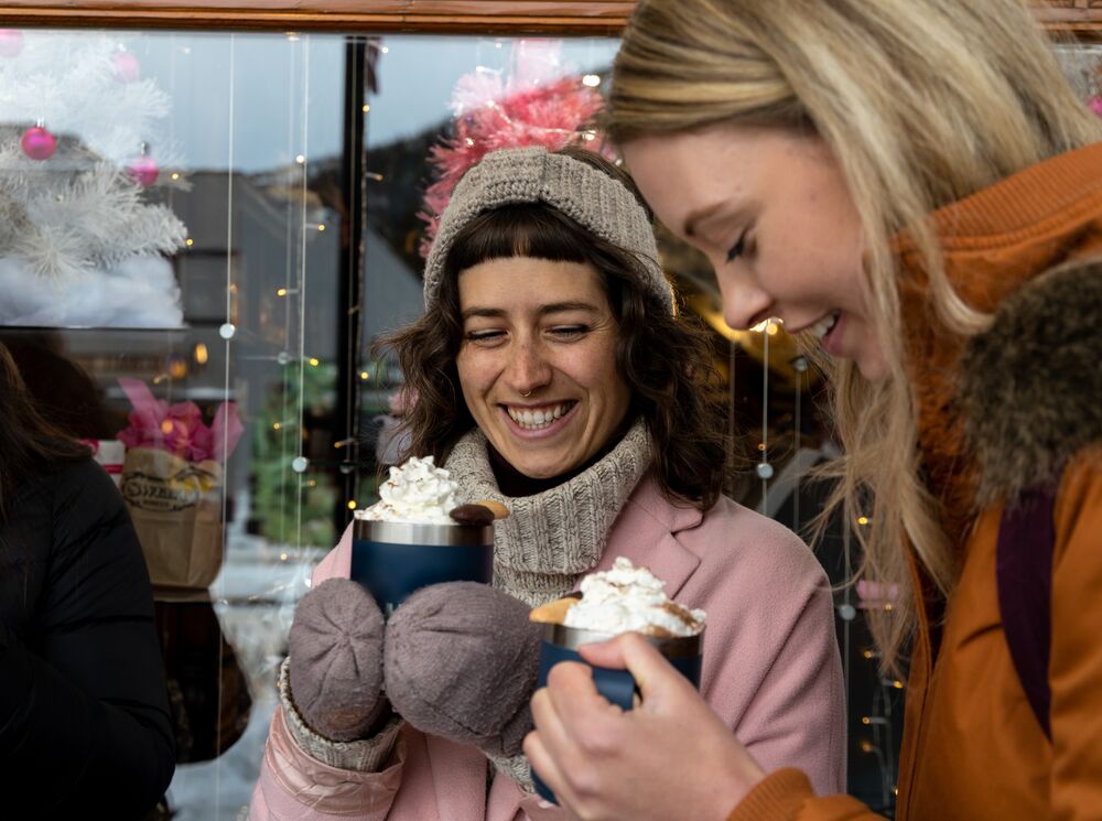 Two people enjoying hot chocolates for the hot chocolate trail in Banff