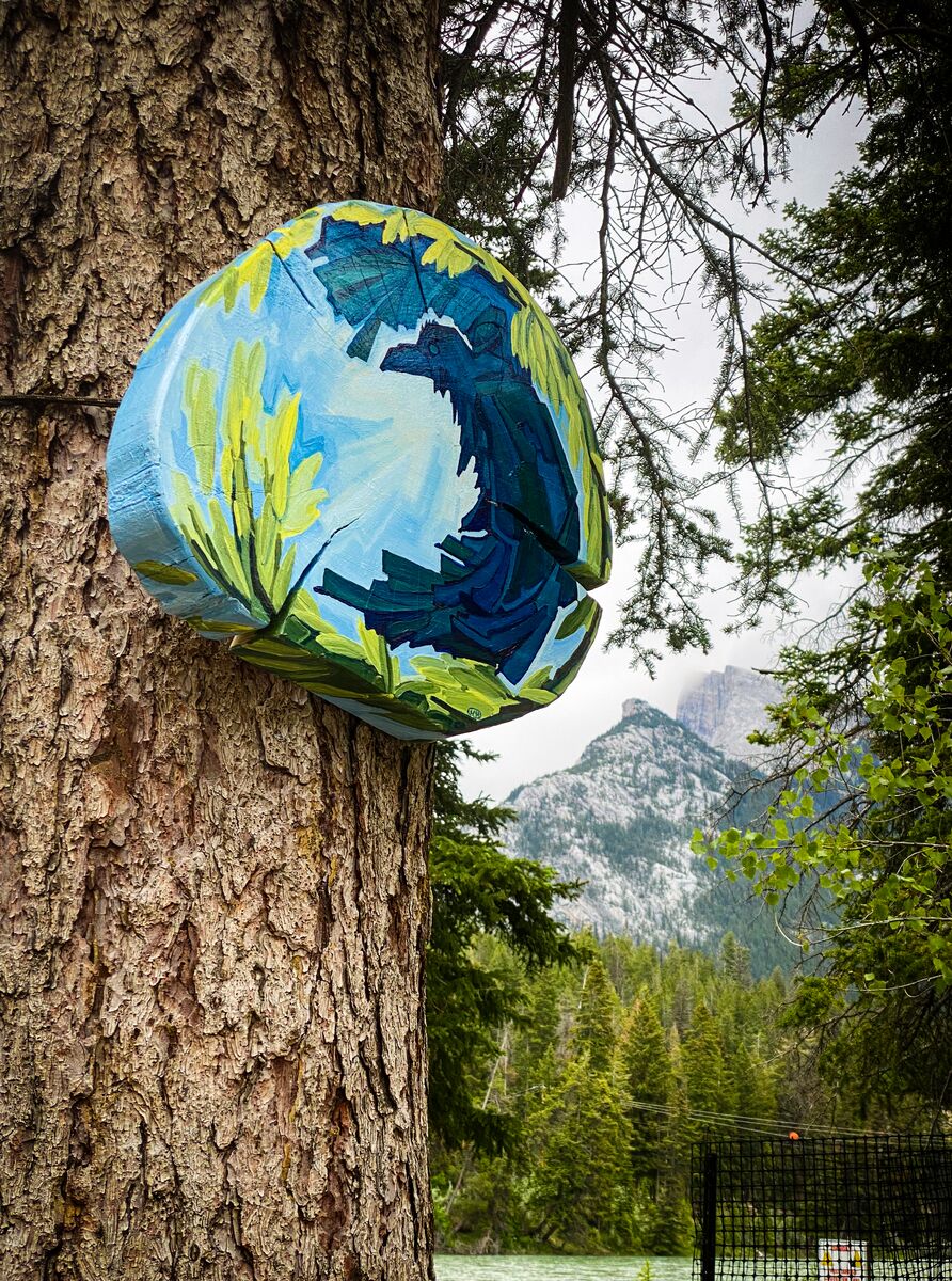 A painting on a tree on the Arti n Nature Trail with Mount Rundle in the background.